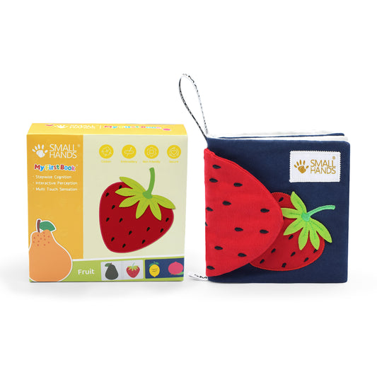 Small Hands Bunte Früchte ausgepackt neben der Verpackung. Eine Erdbeere ist auf dem Buch außen sichtbar. Auch das Knisterpapier ist in Form einer Erdbeere gestaltet. Es ist kontrastreich in rot, grün und blau Design.